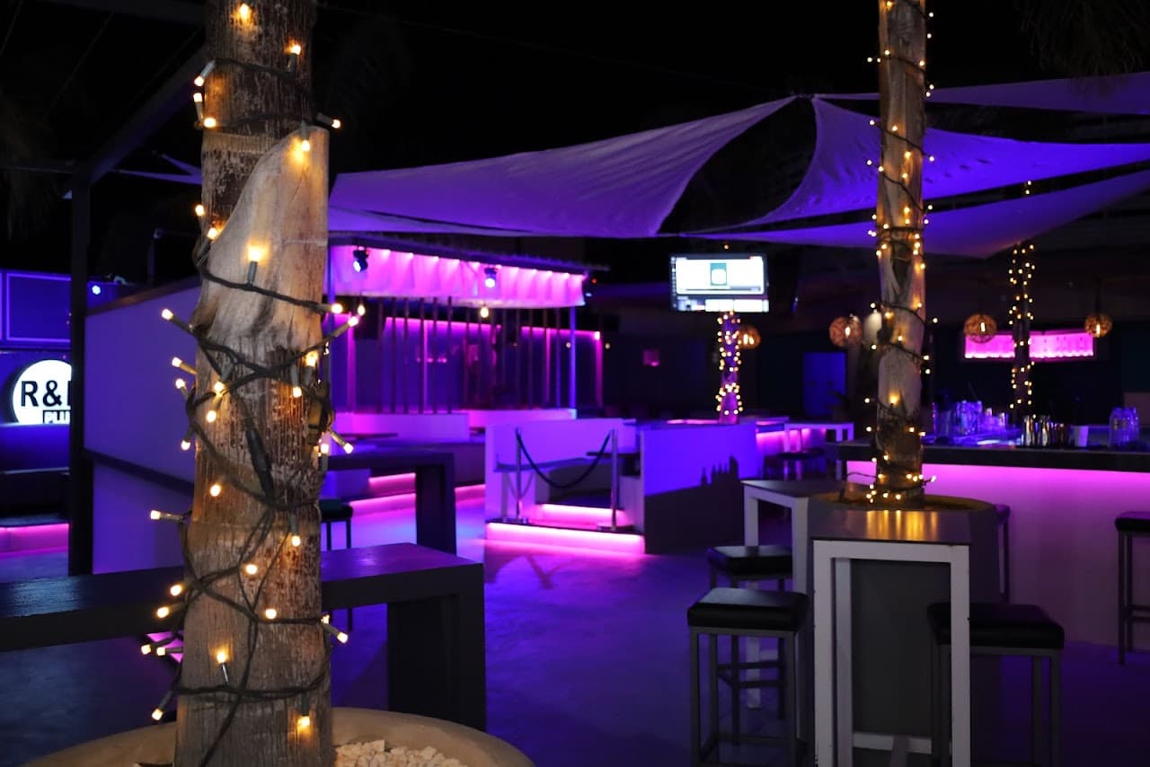 R&B Plus open-air bar under purple light and sail canopies in Malia